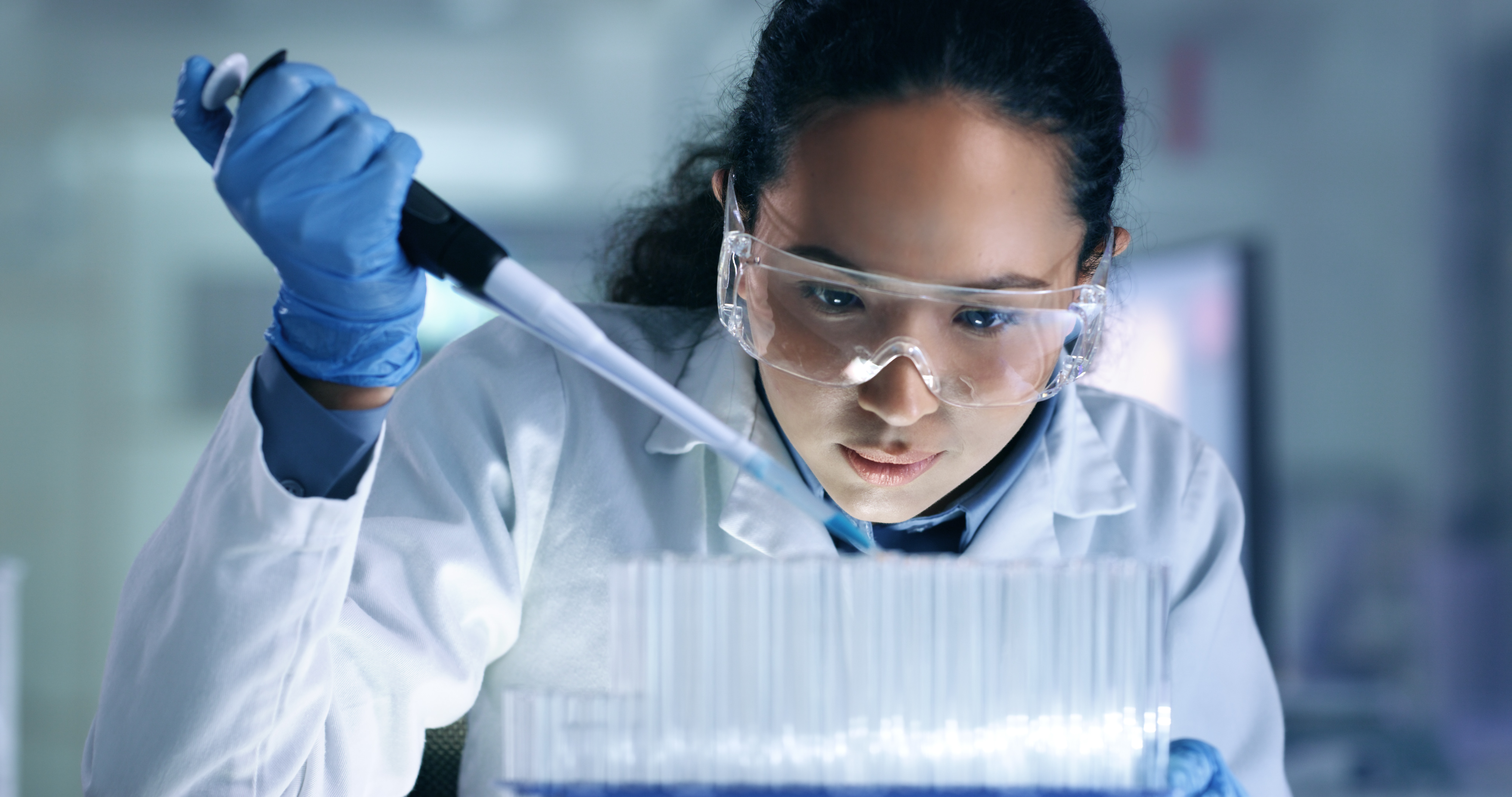 A lab scientist pipetting a sample into test tubes